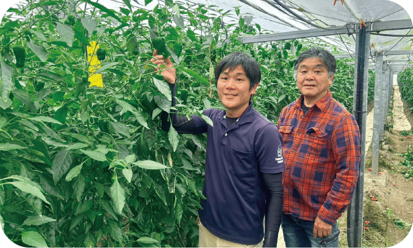 作物の成長を確認する笑顔の男性たち。