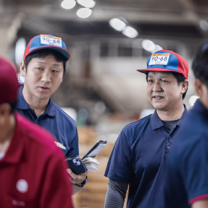 倉庫内で作業員が打ち合わせをしている様子。