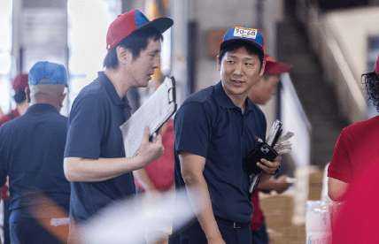 倉庫内で作業員が打ち合わせをしている様子。