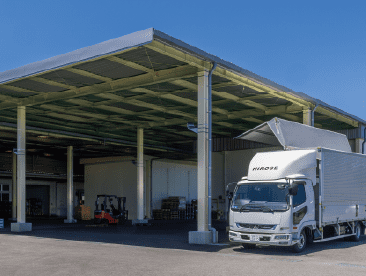 屋根付きの施設に大型トラックが停車している。